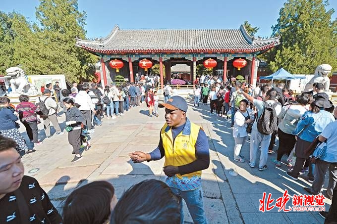 陈旭在圆明园南门引导游客排队检票，这个假期，他安排了两天来这里“为人民服务”。
