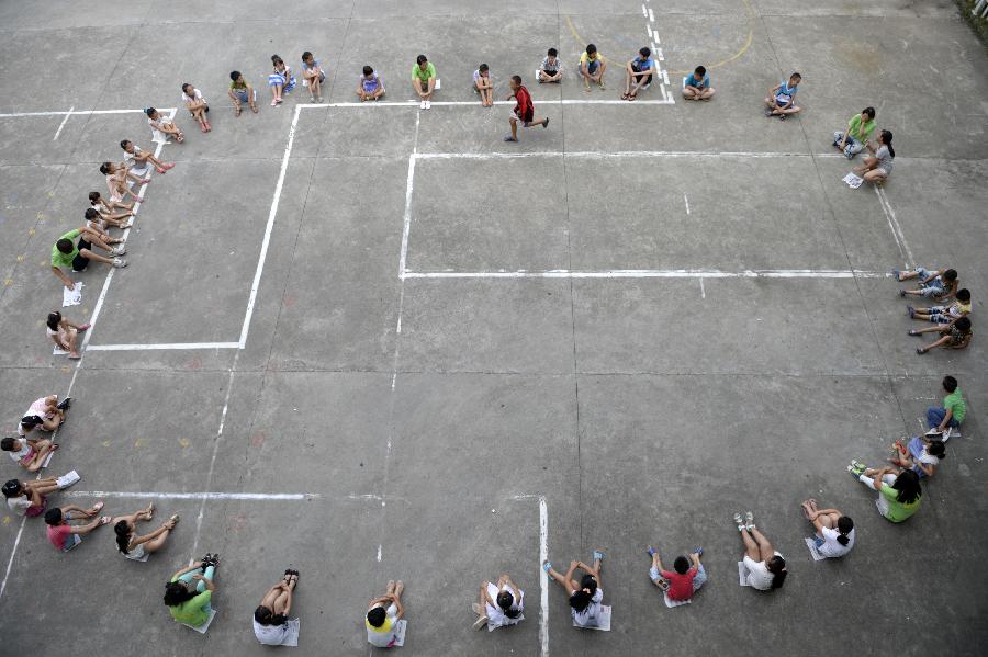 7月28日，在桐庐县钟山乡城下村，大学生志愿者在与村里的小朋友一起做游戏。新华社记者 鞠焕宗 摄